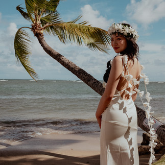 bride shows off wedding dress with palm tree in the back during desitnation elopement