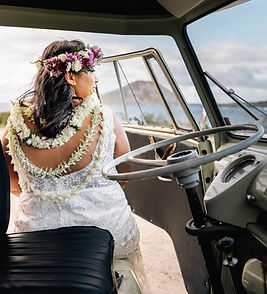 Bride sits in the drivers seat overlooking makapuu during VW truck elopement package with Oahu officiant