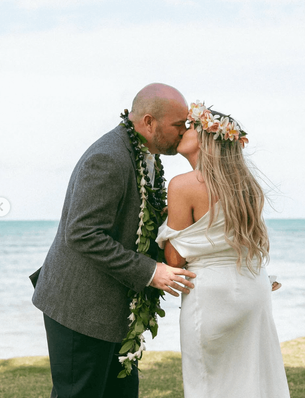 bride, groom, and their daughter share a first kiss 