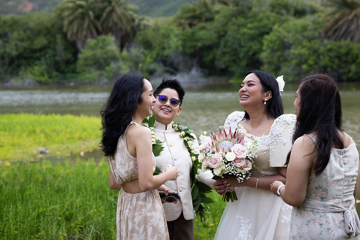 LGBTQ couple laughs with friends and family at their microwedding in Oahu, Hawaii with Oahu Officiant Nicole