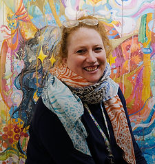 art teacher in front of student artwork