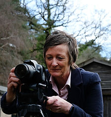 photography teacher looking at a camera on a tripod