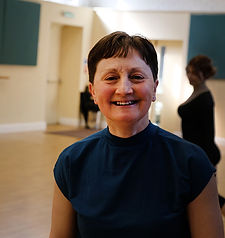 dance teacher in dance studio with student behind