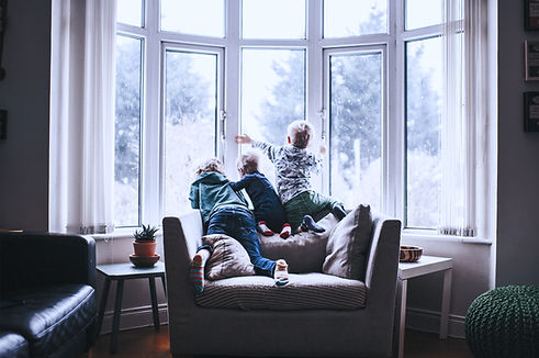 Three boys look out snowy window