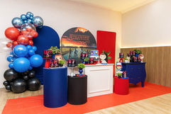 Decoração temática colorida com balões, bolo e personagens na mesa principal durante cobertura fotográfica de festa de aniversário em Jundiaí.