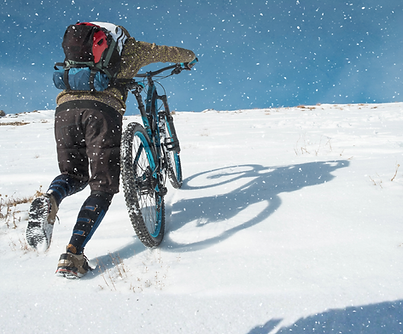 Man Walking Bike In The Snow.png