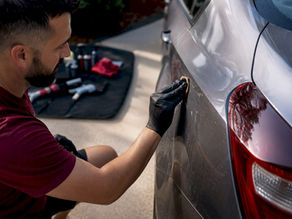 Auto detailer removing water spots with clay bar