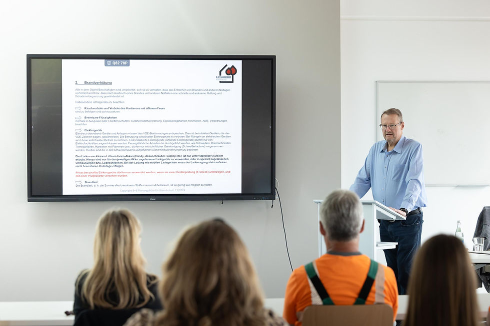 Werner Schreck in einer Schulungssituation. Er Präsentiert Informationen über eine Präsentation. 
