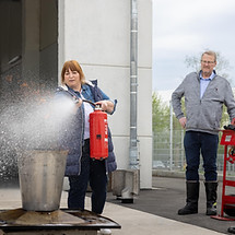 Eine Mitarbeitende löscht ein Feuer in einer Übungsumgebung
