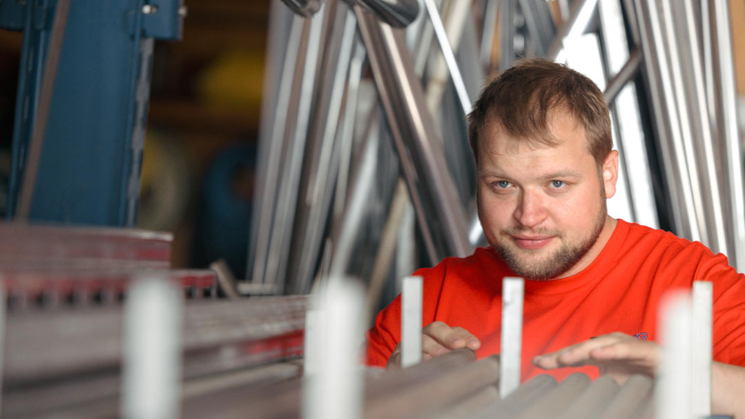 Mitarbeiter blickt auf Material im Lager