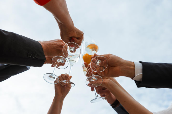 Gäste stoßen zusammen mit Sektgläsern an