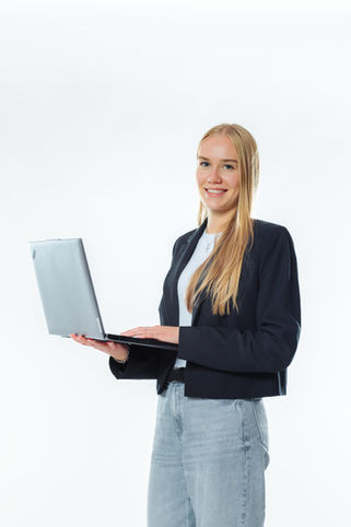 Junge Frau, die einen Laptop hält und lächelt. 