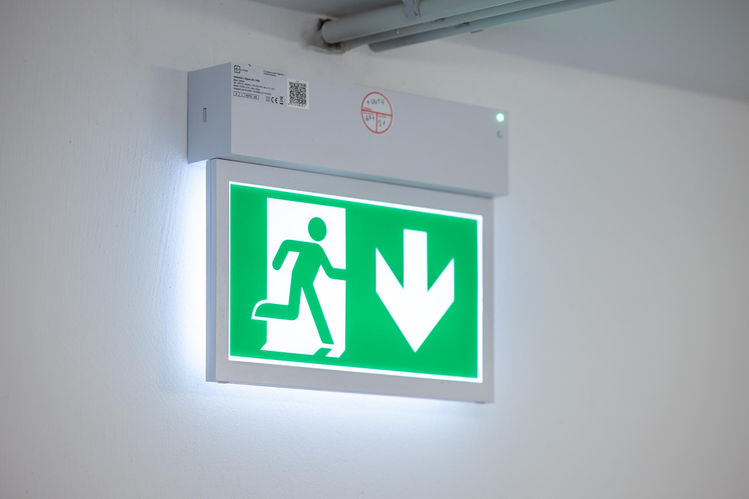 Ein leuchtendes Schild zeigt den Fluchtweg an.