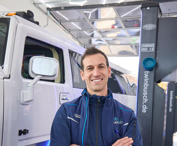 Markus Beutmiller im Einzelfoto vor einer weißen Limousine.