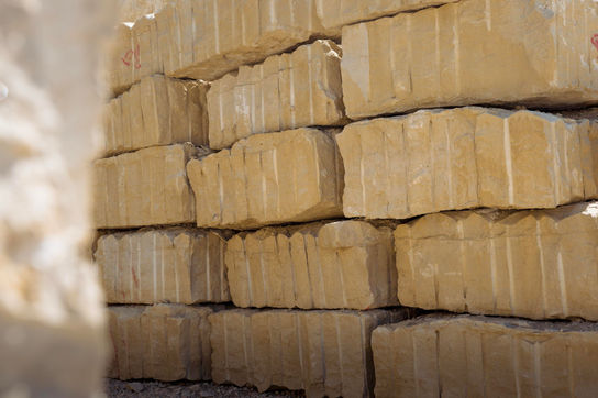 Gestapelte gelbe Steine, Nahaufnahme. Viele Quader Steine am Lagerort.