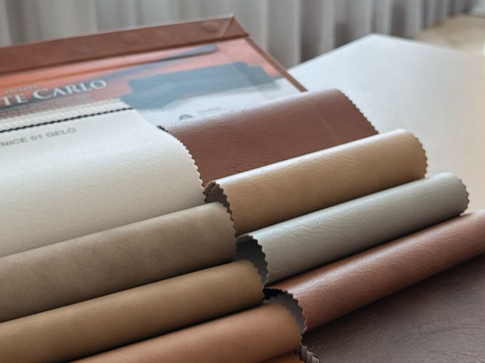 Cabeceira de cama estofada em couro sintético, com acabamento firme e estrutura reta, exemplo de aplicação ideal do material em estofaria sob medida.