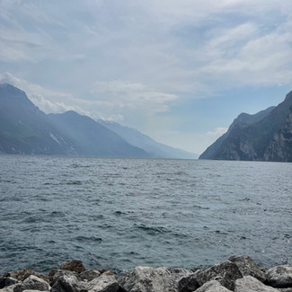 Stunning scenery of water and foggy mountains in distance photographed by Acela ' Ace ' Kandola at Lago Di Garda