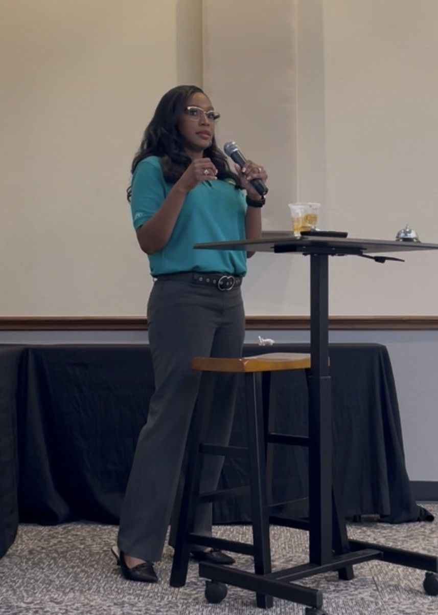 Lee Caldwell speaking to a group of business professionals during a live educational presentation.