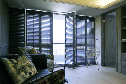 Black Normandy shutters featured in a contemporary living room with large windows