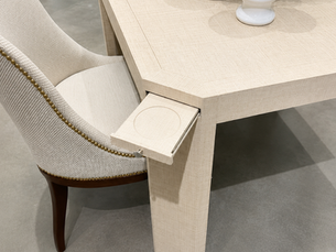 Designer game table featuring integrated pull-out drink tray and textured raffia-inspired finish.