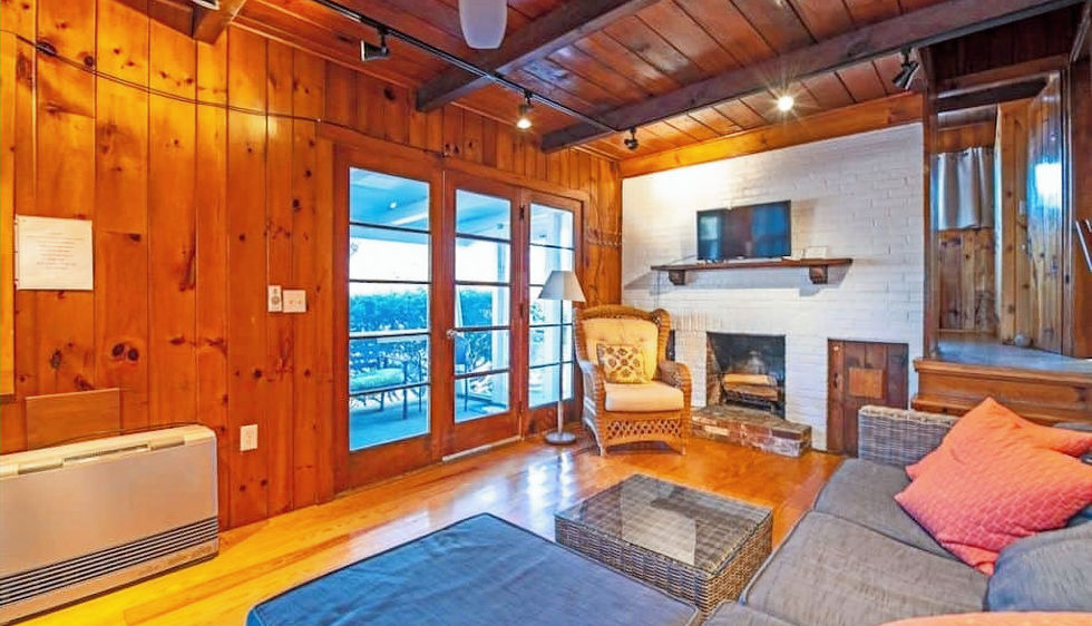 Sea View oceanside cottage living room with fireplace, couch, and tv