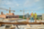 back-view-experienced-construction-engineer-hardhat-pointing-crane-two-workers-safety-vest
