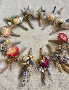 Handcrafted dried flower wedding buttonholes featuring soft textures and neutral tones, perfect for grooms and groomsmen.