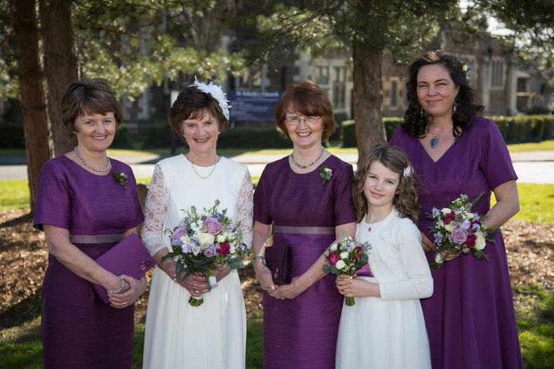 Elegant bridal and bridesmaids bouquets combining white, purple, and burgundy flowers in a sophisticated arrangement.