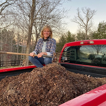 Sallie sitting in the bed of a truck with materials that will be added to her worm bin.
