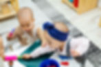 Several toddlers grabbing a toy rolling pin