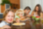Parents and two children eat together