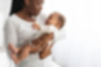 A concerned-looking mother holds a fussy baby.