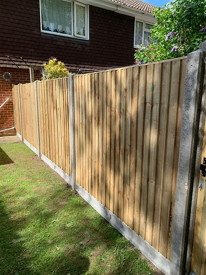 Wooden panel fence with concrete base