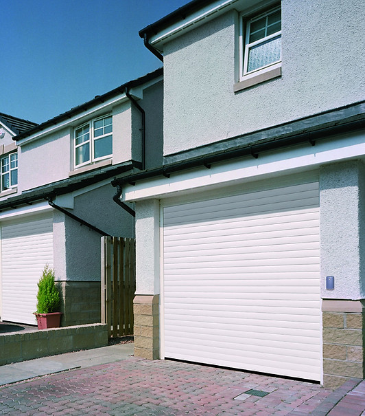 White roller garage doors on a house with block paving driveway