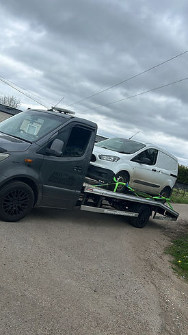 White van being towed by recovery truck