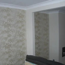 Decorator wallpapering living room