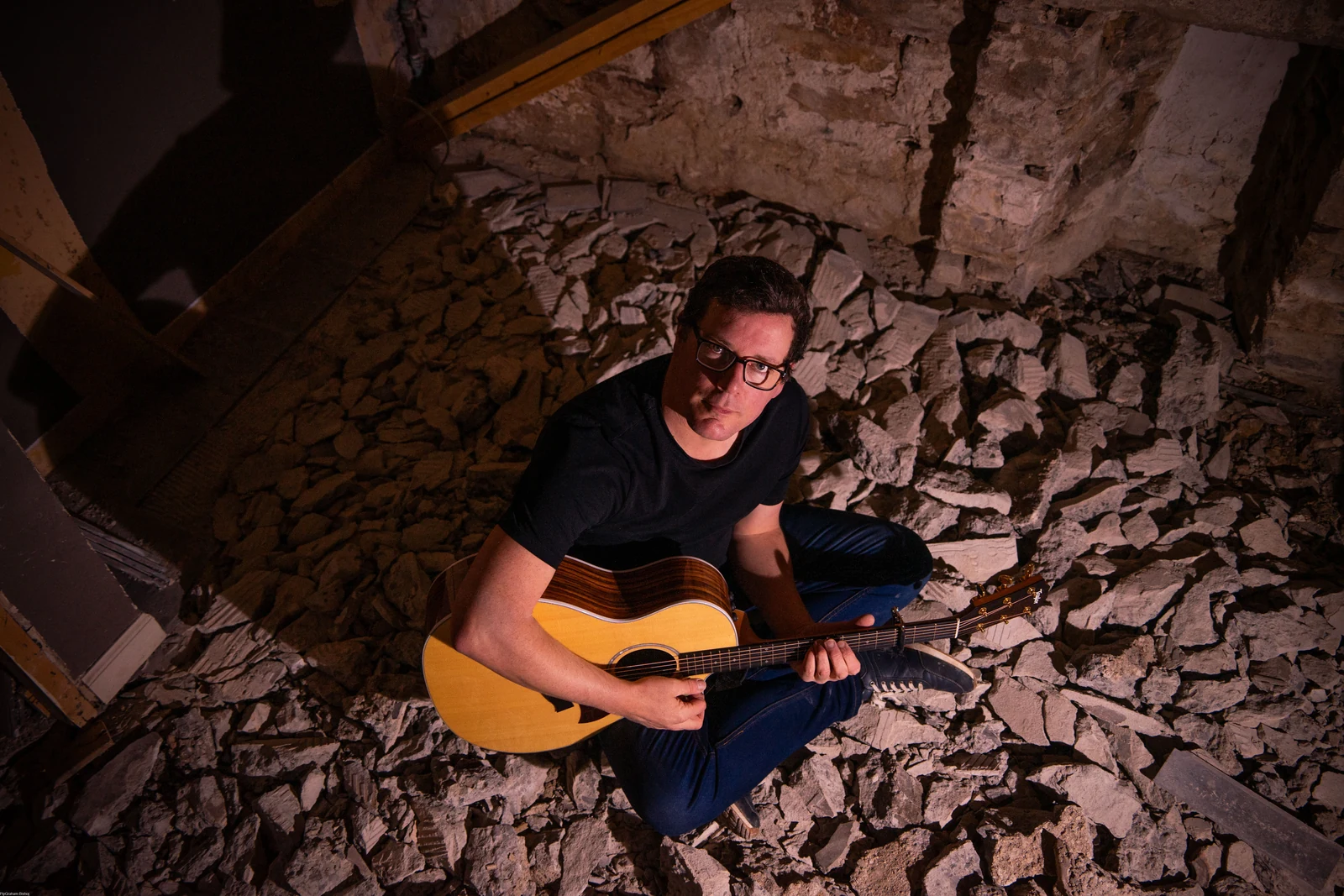 Donald with a guitar in a stone interior