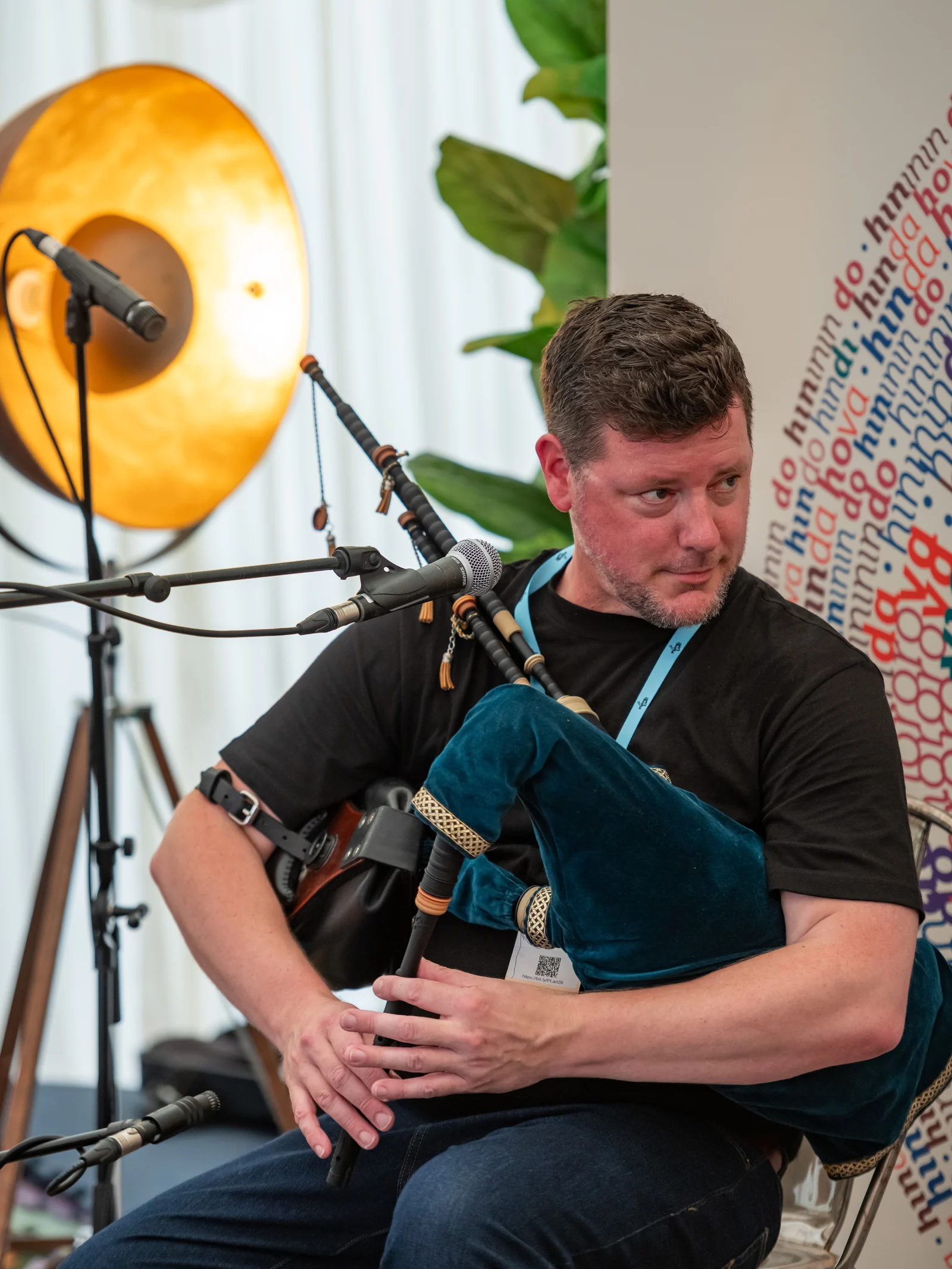 Donald holding his smallpipes and looking towards Roo at Piping Live