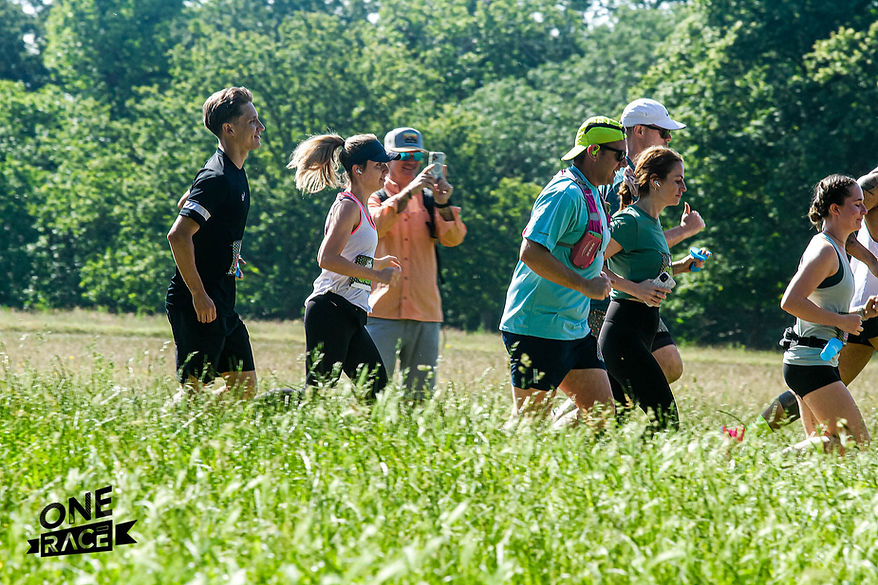 A group of runners participating in the OneRace Richmond Park Half Marathon and 10k, racing through the scenic trails of London
