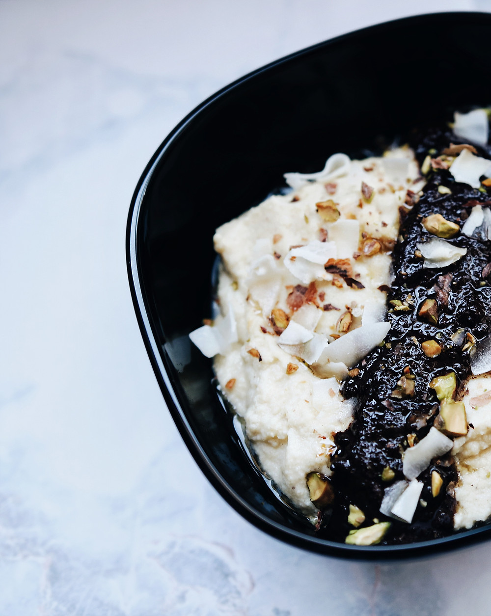 A closer view of the coconut porridge, with melted chocolate toasted coconut and pistachio pieces.