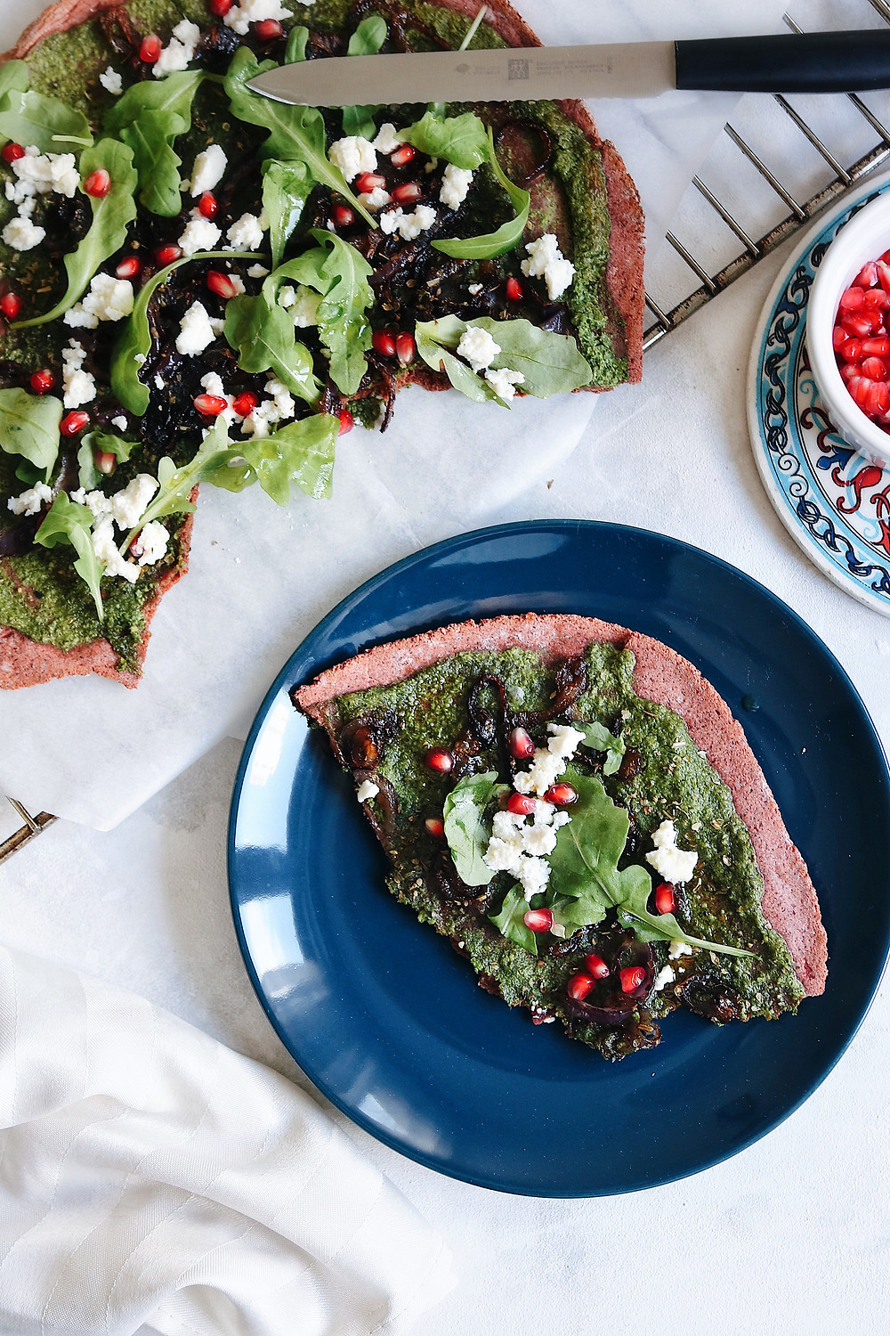 A gluten free beetroot crust pizza with arugula pesto cut through.