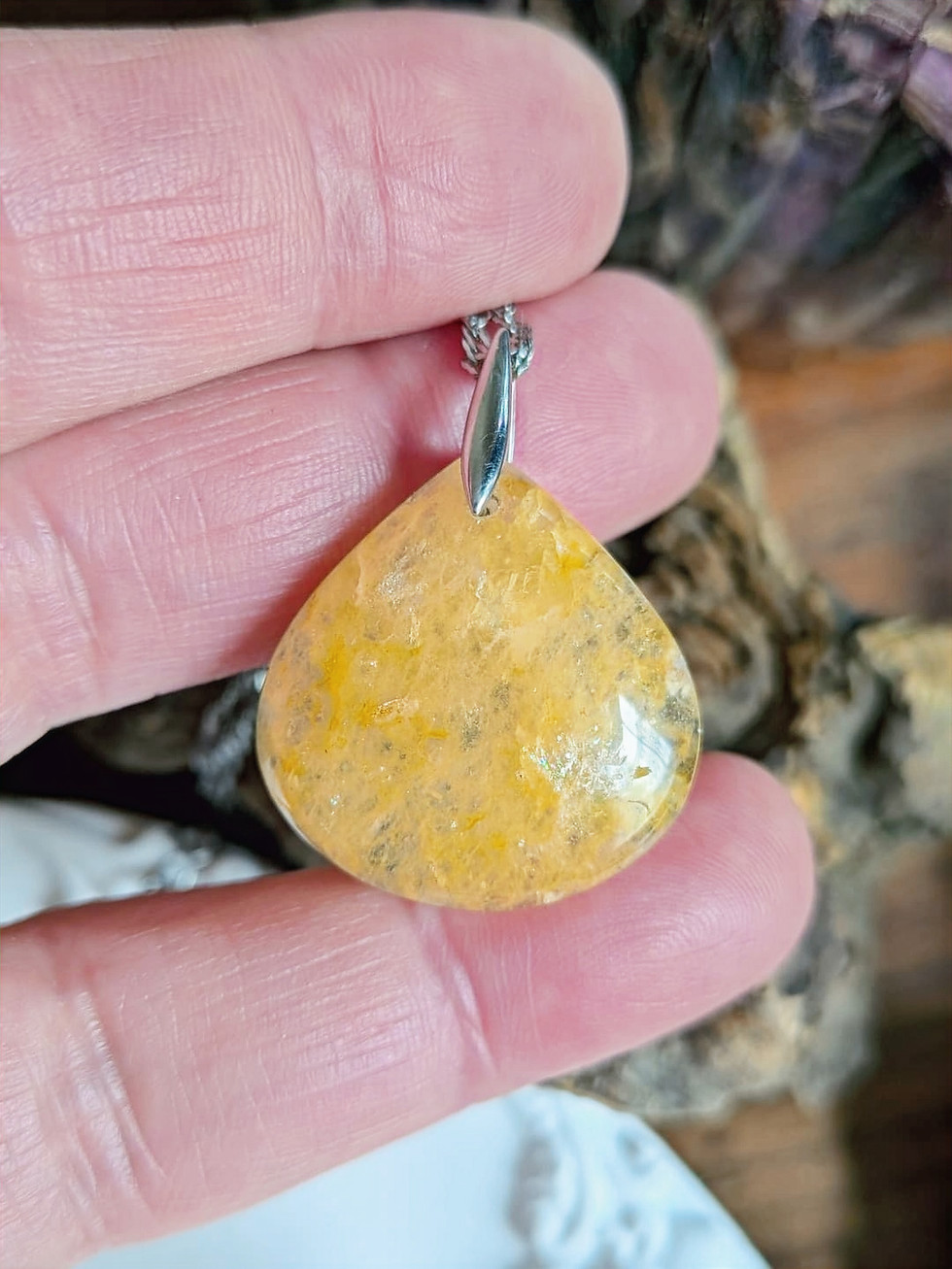 Pendentif en aventurine jaune orangée, percée à l'atelier, avec bélière argent, tenue à la main par la créatrice, collection minimaliste, Adralhia bijoux