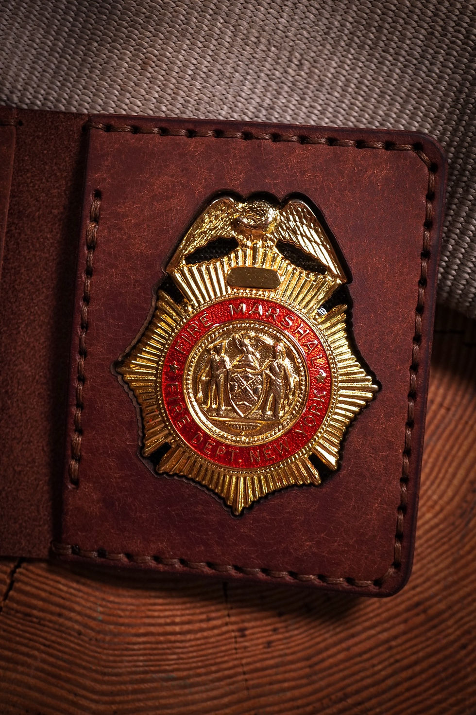 Brown leather badge wallet with an FDNY Fire Marshal badge and ID window