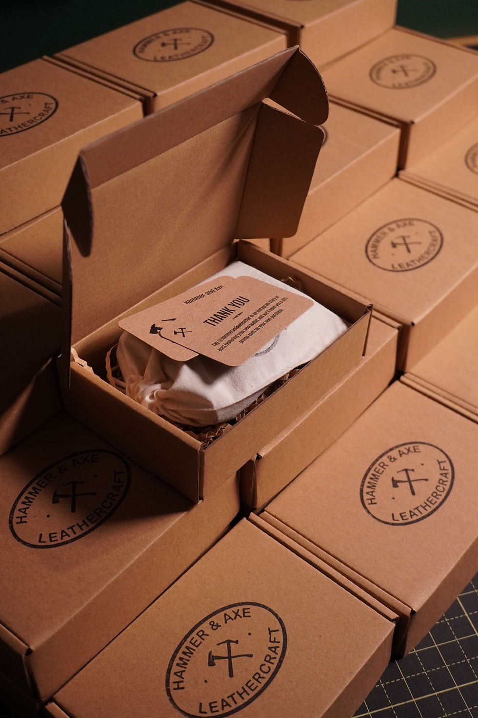 Hammer and Axe branded presentation boxes and an open box containing a cloth pouch and thank-you card