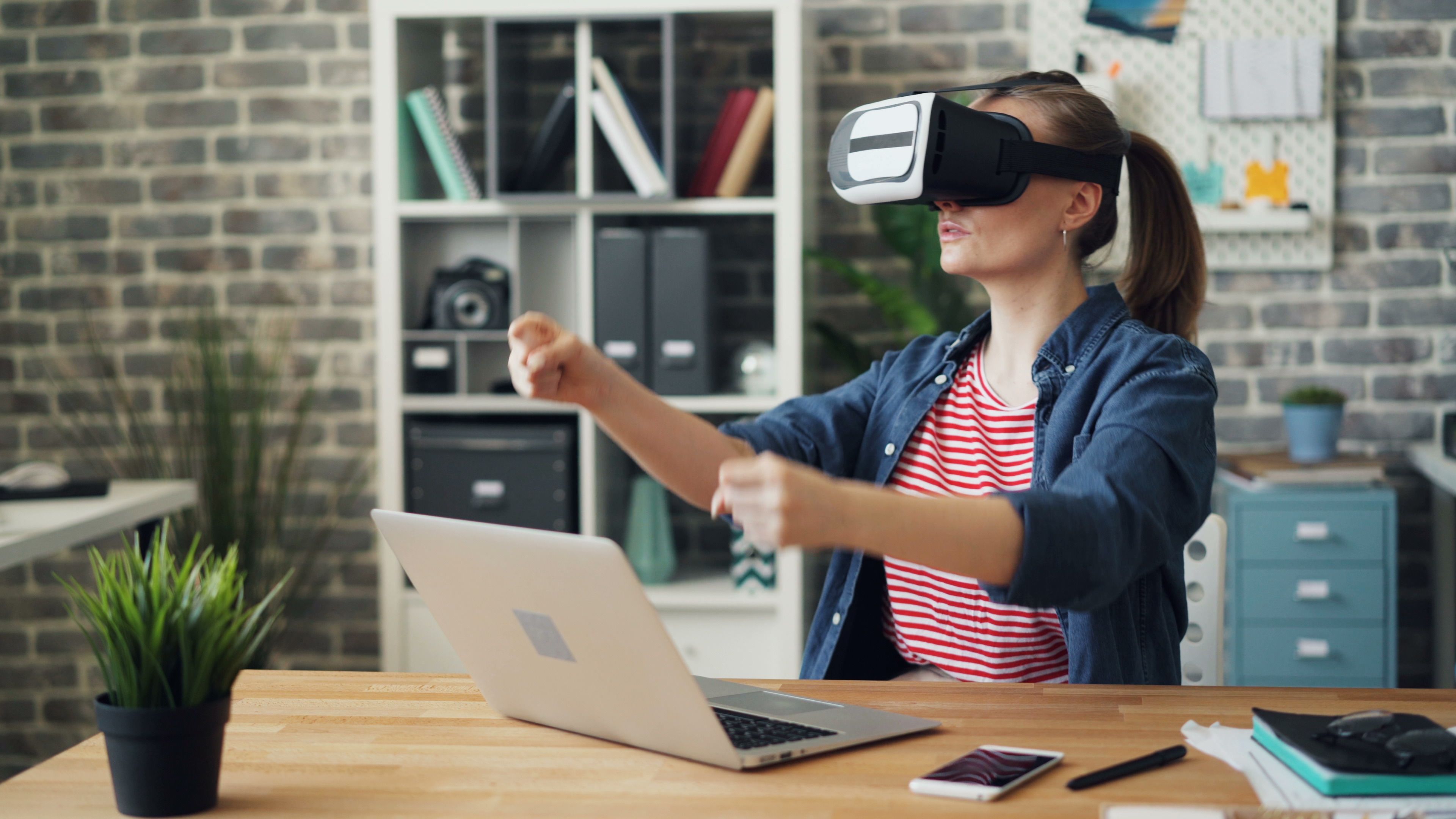 Woman using a virtual reality headset at a desk in a modern office