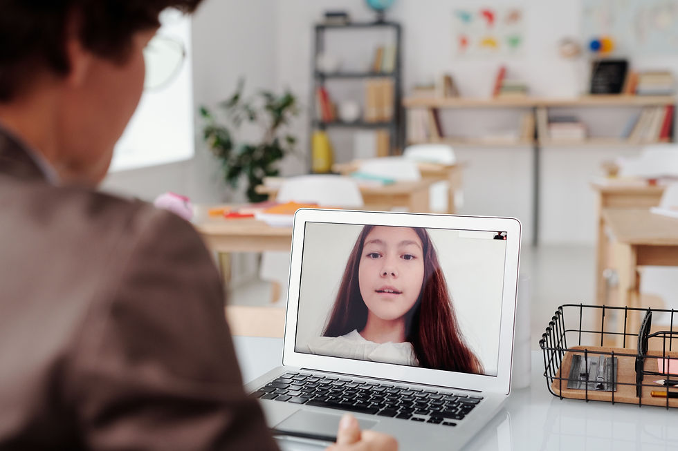 Teacher conducting a remote lesson with a student on a laptop