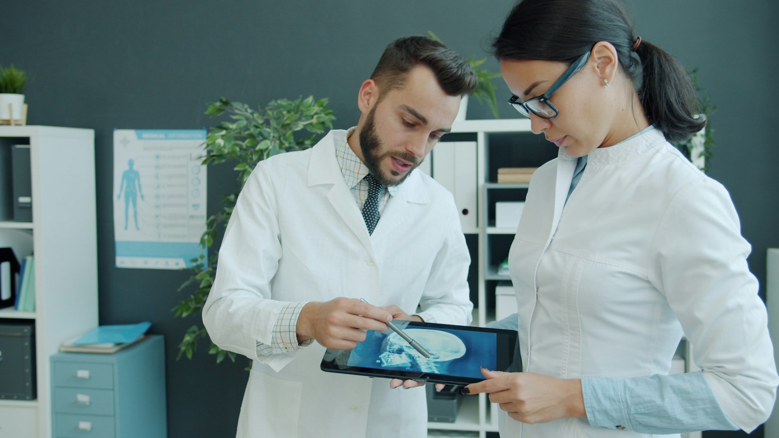 Two doctors reviewing medical imaging on a tablet together