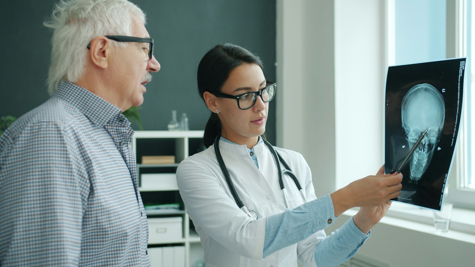 Doctor discussing an X-ray with an older patient during a consultation