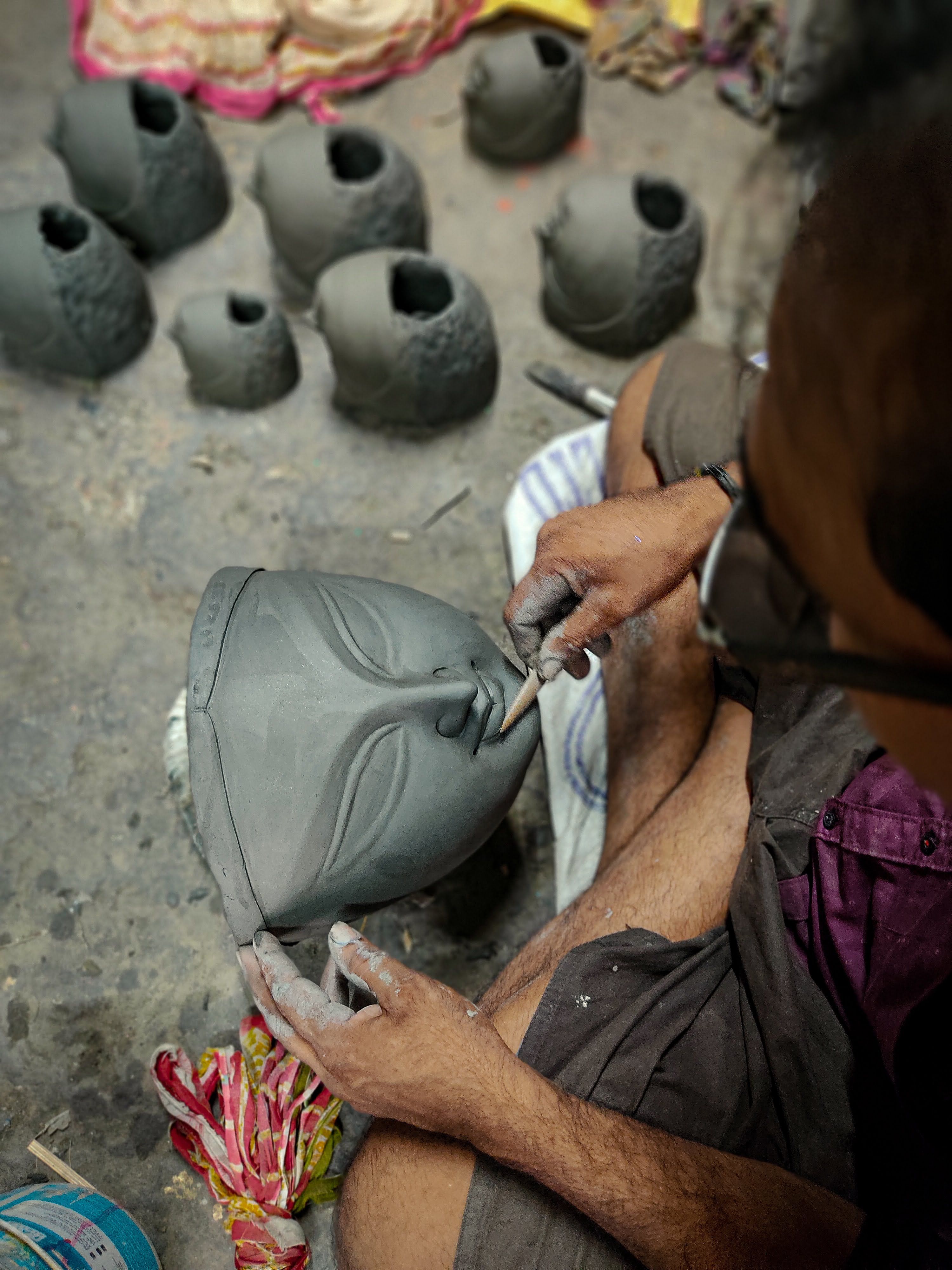 Craftsperson refining a sculpted mask as a reference for production-ready monster assets