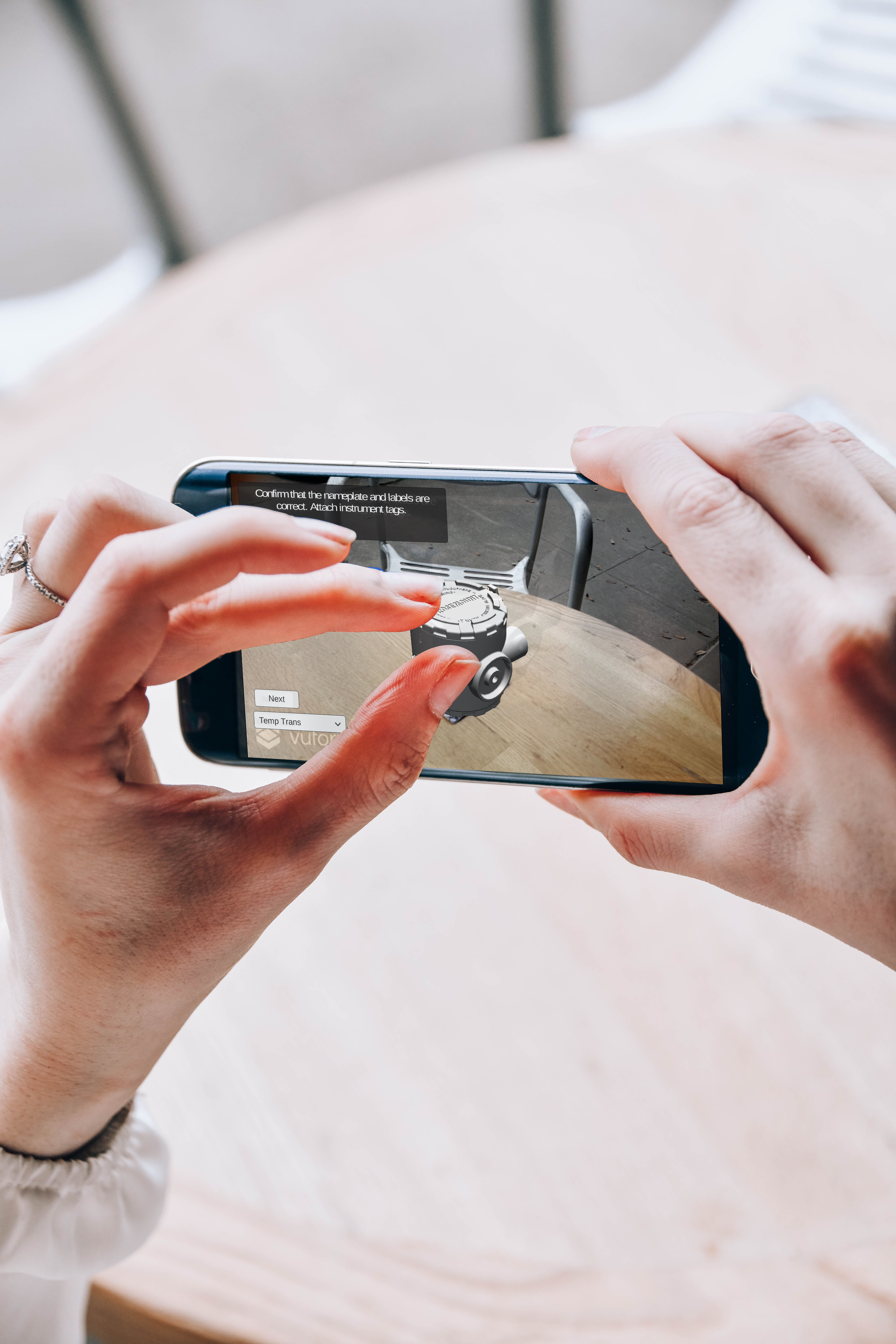 Hands holding a smartphone with an augmented reality application